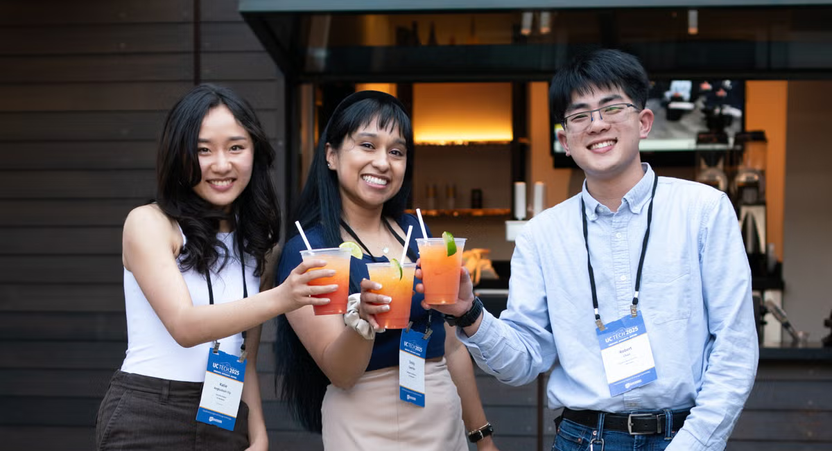 Attendees holding drinks and smiling