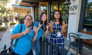 uc employees smiling and pointing at the camera