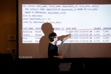 UC Tech 2025 speaker presenting for their session, pointing at their slide..