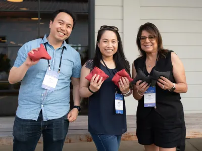 UC Tech 2025 attendees posing with bean bags after a game or cornhole.
