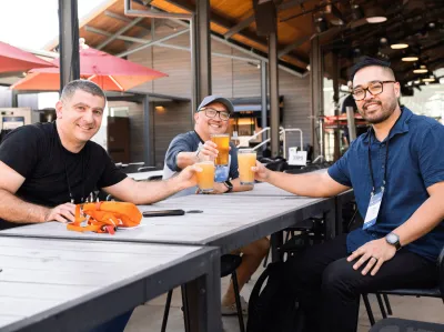 UC Tech 2025 attendees posing with their drinks at the Welcome Reception.