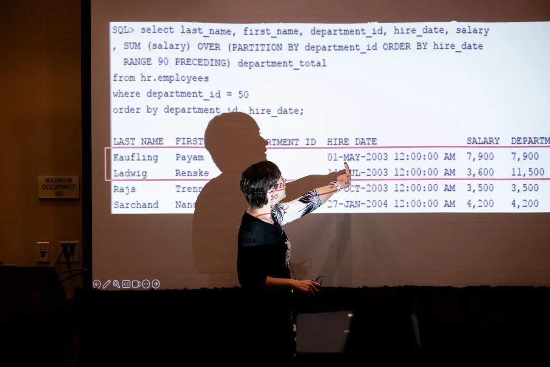 UC Tech 2025 speaker presenting for their session, pointing at their slide..