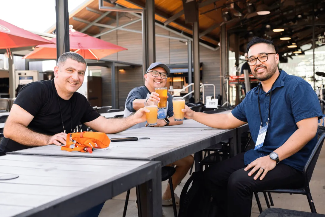 UC Tech 2025 attendees posing with their drinks at the Welcome Reception.